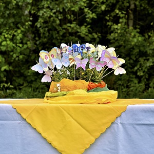 Papierschmetterlinge, die im Blumentopf zwischen Blumen stecken