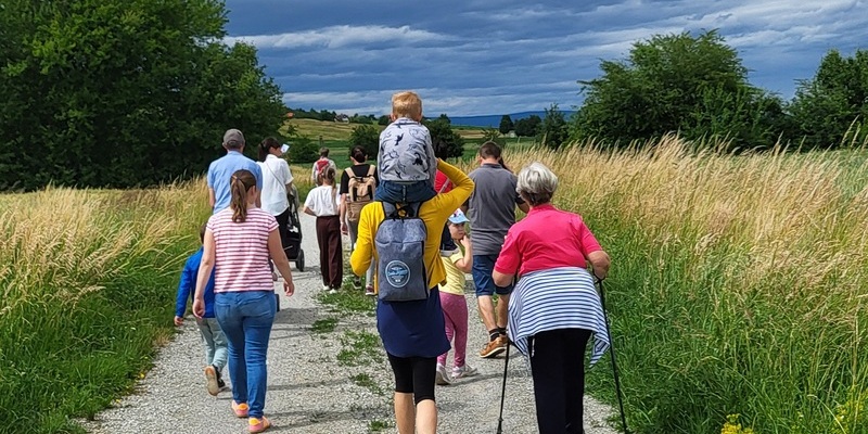 Menschen von jung bis alt auf einem Feldweg