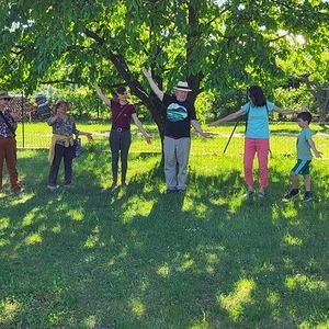 Menschen stehen auf einer Wiese im Kreis 