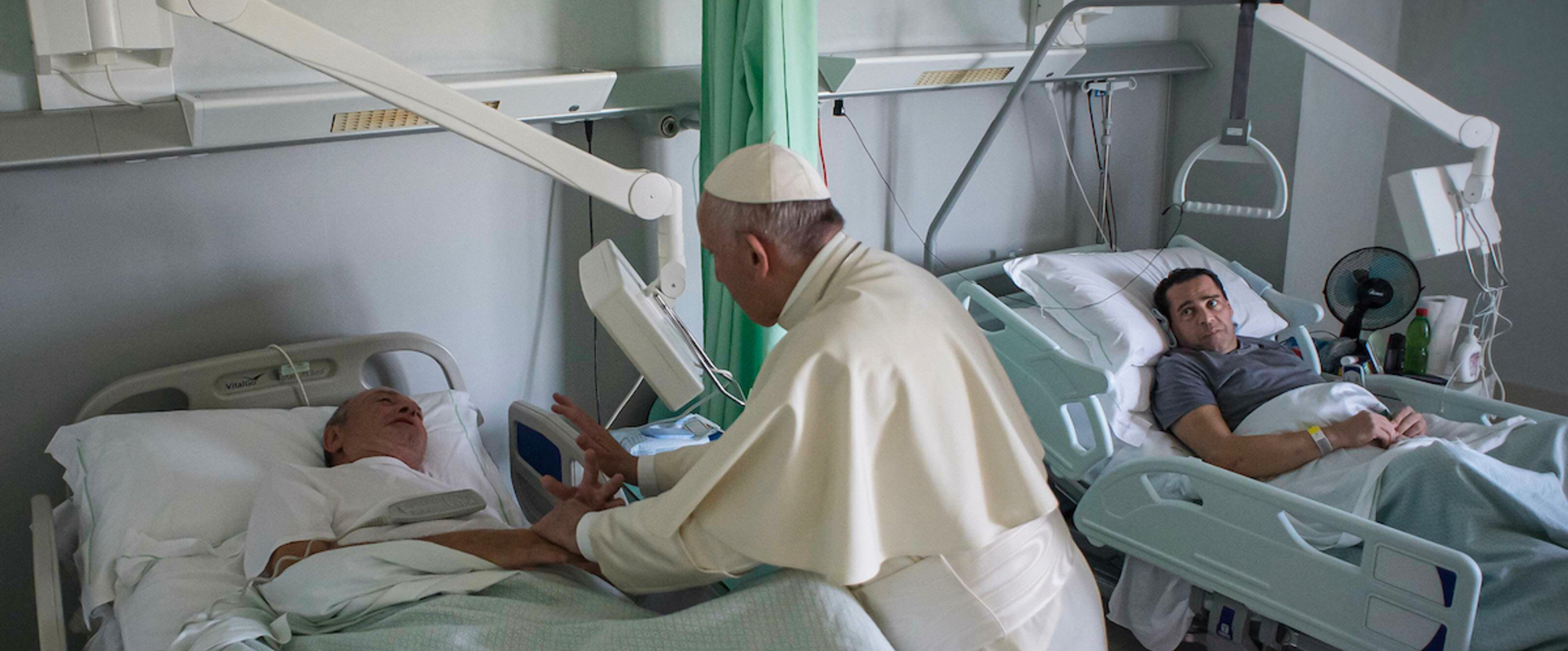 Papst Franziskus steht am 22. September 2017 am Bett eines kranken Mannes und hält seine Hände im Rehabilitationszentrum der Stiftung Santa Lucia in Rom. Der Papst besucht einmal im Monat an einem 'Freitag der Barmherzigkeit' Einrichtungen für Kranke