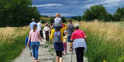 Menschen von jung bis alt auf einem Feldweg