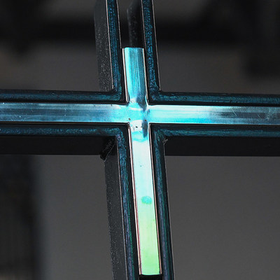 Blaues Licht spiegelt sich im Altarkreuz im Innenraum der Kirche Sankt Ludgerus am 3. Juli 2020 in Norderney.