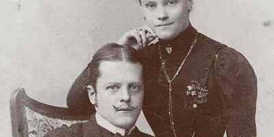 Dr. Ladislaus sitzend, rechts hinter ihm steht seine Frau.