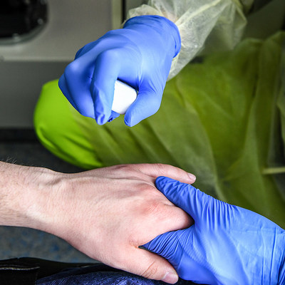 Ein Rettungssanitäter desinfiziert den Handrücken eines Notfallpatienten im Rettungswagen während einer Übung in Bonn am 17. April 2021.