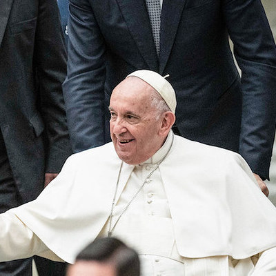 Jugendliche reichen Papst Franziskus ihre Hände bei dem vom italienischen Netzwerk 'Schulen des Friedens' geförderten Treffen in der Audienzhalle, am 28. November 2022 im Vatikan.