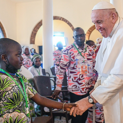 Papst Franziskus reicht einem Kind die Hand bei einem Treffen mit Opfern von Gewalt im Ostkongo am 1. Februar 2023 in der Apostolischen Nuntiatur in Kinshasa (Demokratische Republik Kongo).