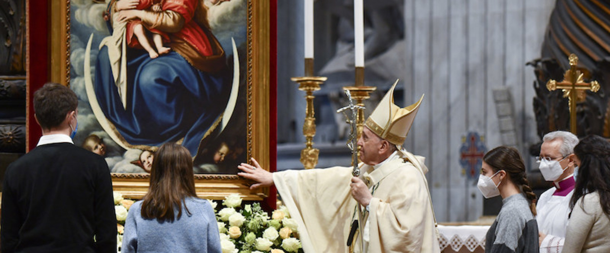 Papst Franziskus berührt das Gemälde einer Madonna, während des Gottesdienstes am Hochfest Christkönig, am 21. November 2021 im Vatikan. Jugendliche stehen um ihn herum.
