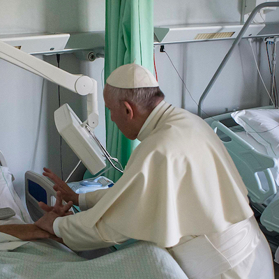 Papst Franziskus steht am 22. September 2017 am Bett eines kranken Mannes und hält seine Hände im Rehabilitationszentrum der Stiftung Santa Lucia in Rom. Der Papst besucht einmal im Monat an einem 'Freitag der Barmherzigkeit' Einrichtungen für Kranke