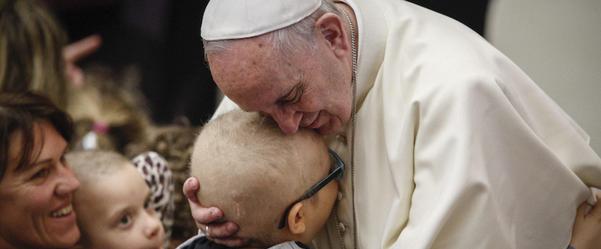 Papst Franziskus umarmt ein Kind während eines Treffens mit behinderten Menschen am 13. Januar 2016 im Vatikan.