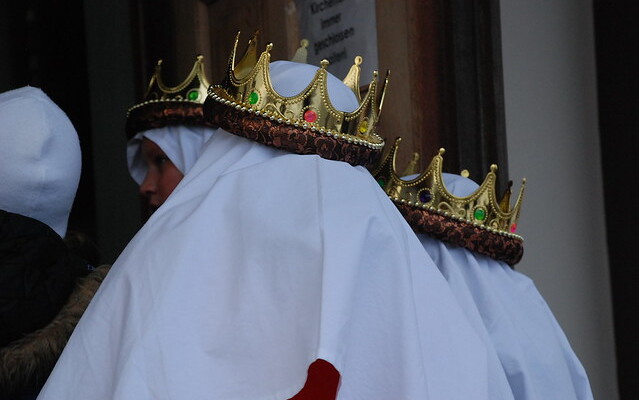 3 goldene verzierte Kronen auf weißen Kopftüchern